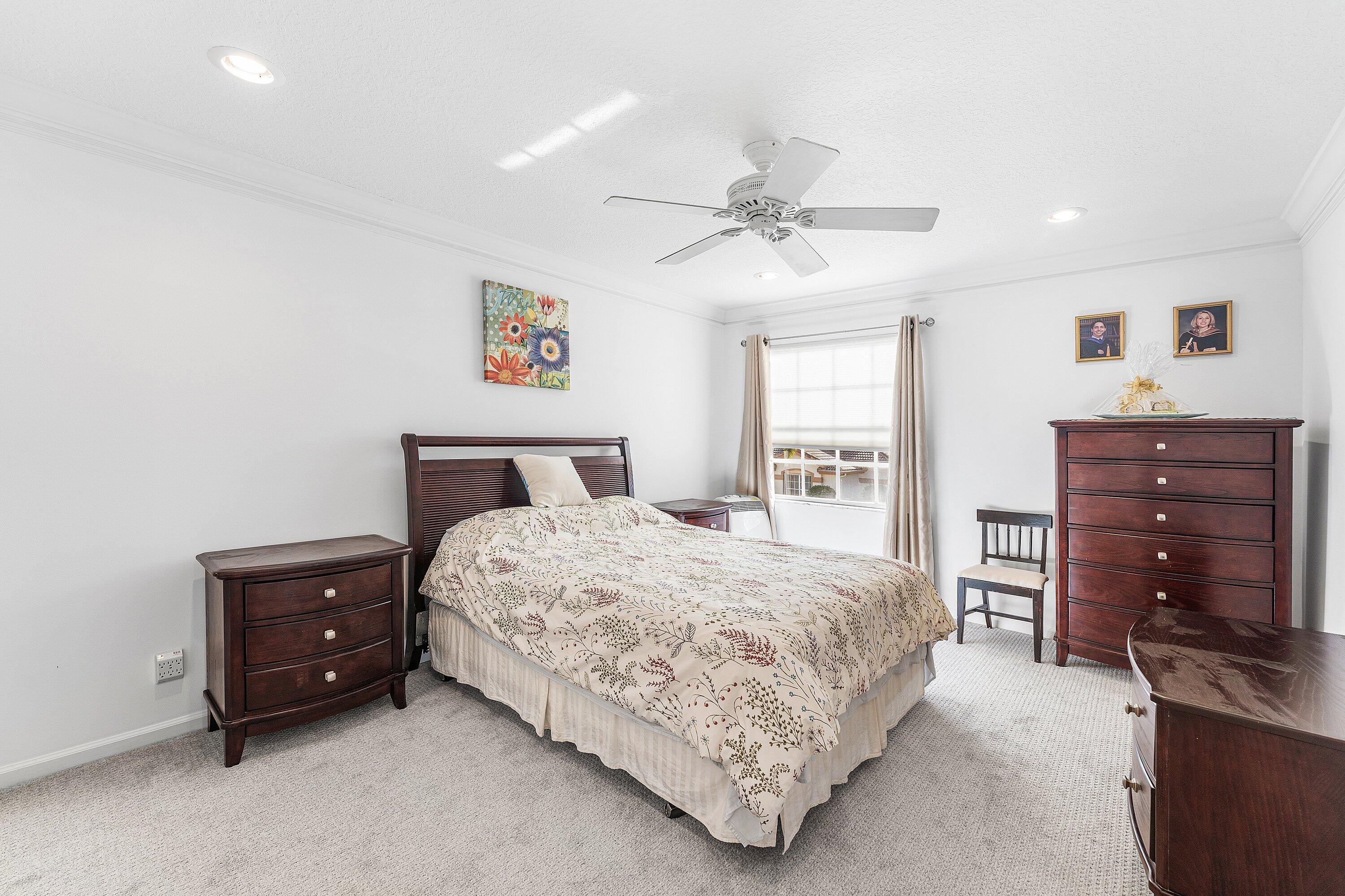 8217 Quail Meadow Way West Palm Beach, FL 33412 - Photo 23 of 38 a bedroom with a bed and a dresser