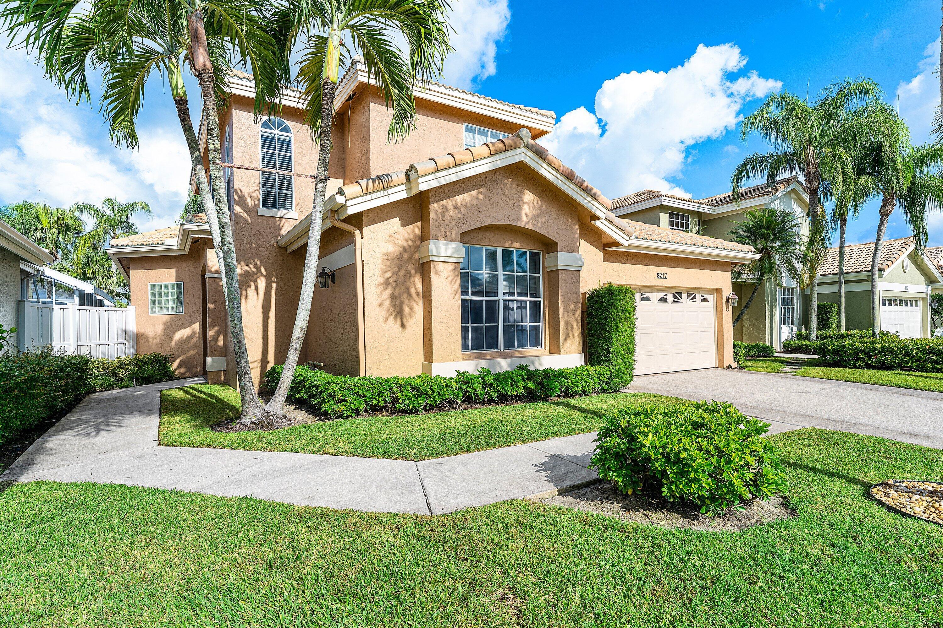 8217 Quail Meadow Way West Palm Beach, FL 33412 - Photo 4 of 38 a front view of a house with a yard and potted plants