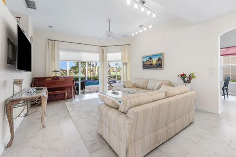 a living room with furniture a flat screen tv and a chandelier