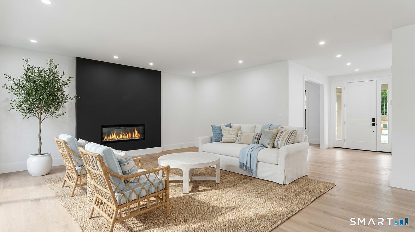 a living room with furniture a fireplace and a potted plant
