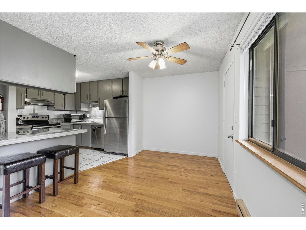 925 Columbia Road, Unit 824 Fort Collins, CO 80525 - Photo 8 of 36 a open kitchen with stainless steel appliances granite countertop a refrigerator a stove top oven a sink dishwasher and white cabinets with wooden floor