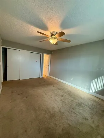 en empty room with windows and fan