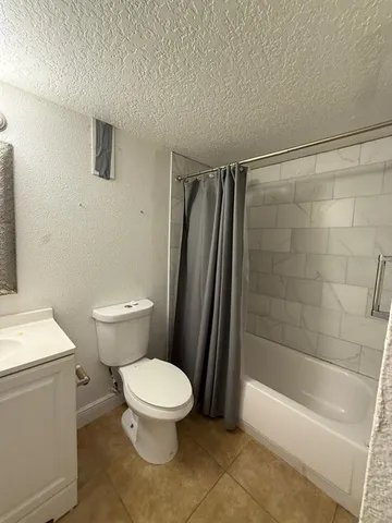 a white toilet sitting next to a bath tub