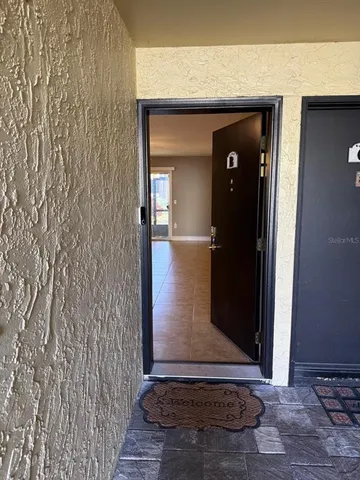 a view of a hallway with wooden floor and front door