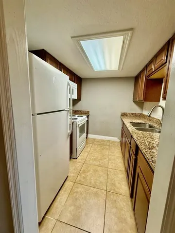 a view of a kitchen with refrigerator and white cabinets