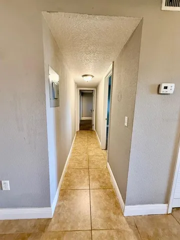 a view of a hallway with wooden floor and a living room