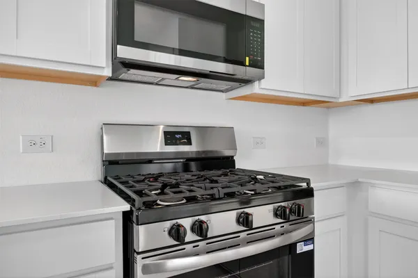 a stove top oven sitting inside of a kitchen