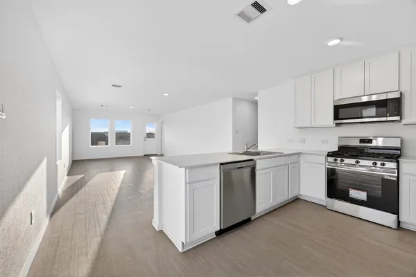 a kitchen with granite countertop a stove top oven and sink