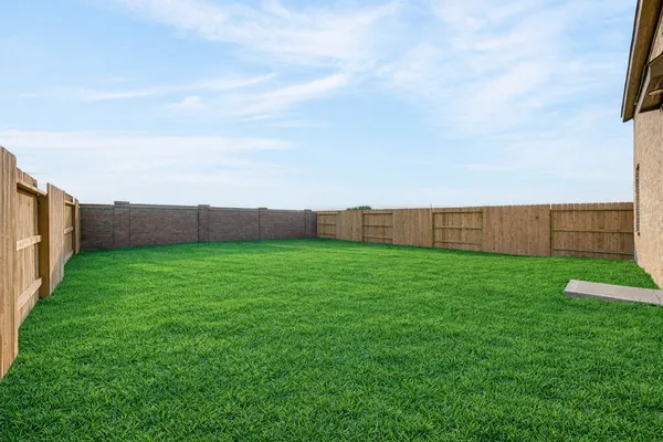 a view of a house with a big yard and large trees