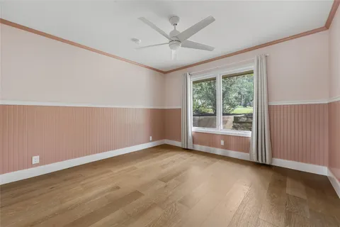 an empty room with windows and ceiling fan