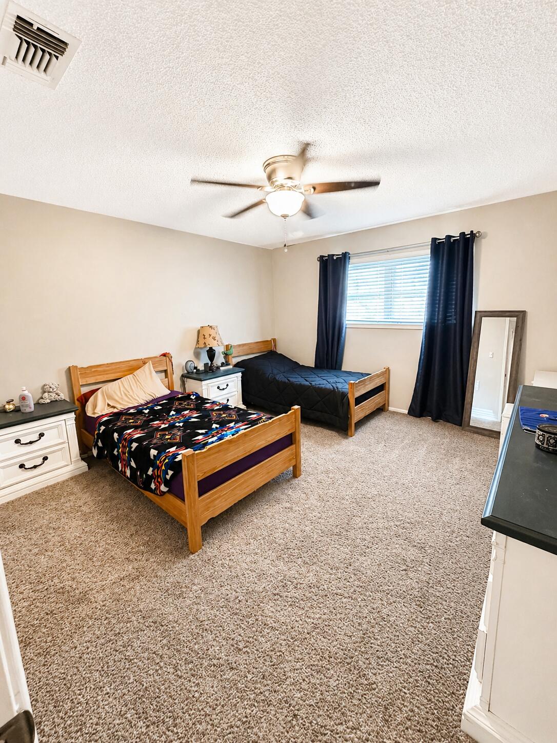 2023 Rice Drive Levelland, TX 79336 - Photo 9 of 15 a bedroom with furniture and a chandelier