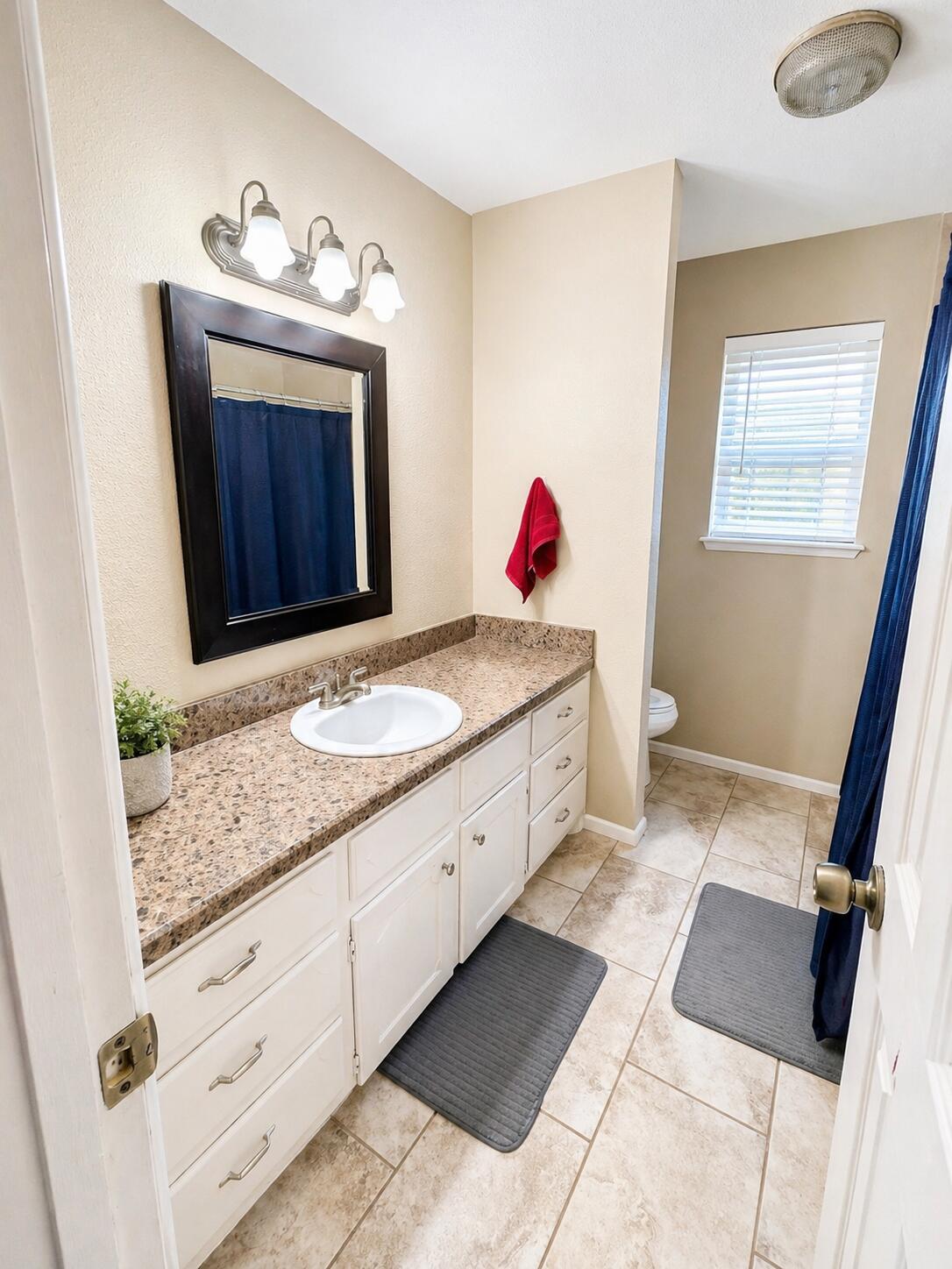 2023 Rice Drive Levelland, TX 79336 - Photo 10 of 15 a spacious bathroom with a granite countertop sink and a mirror