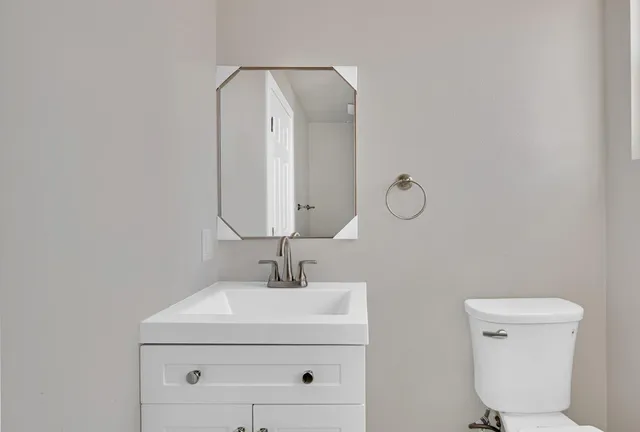 a kitchen with stainless steel appliances granite countertop a sink and white cabinets with wooden floor