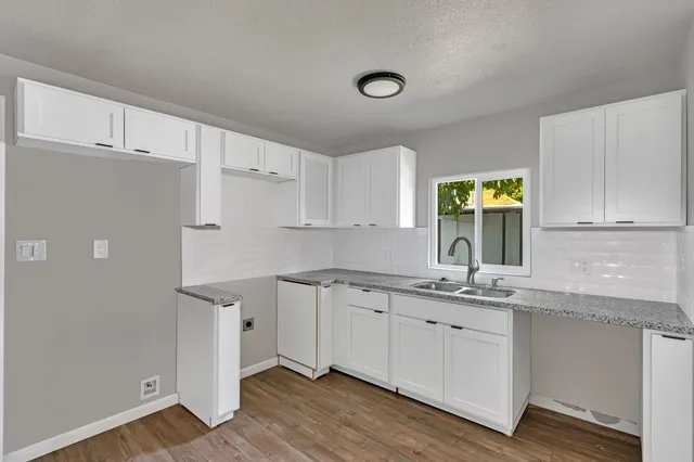 a view of an empty room with wooden floor and closet