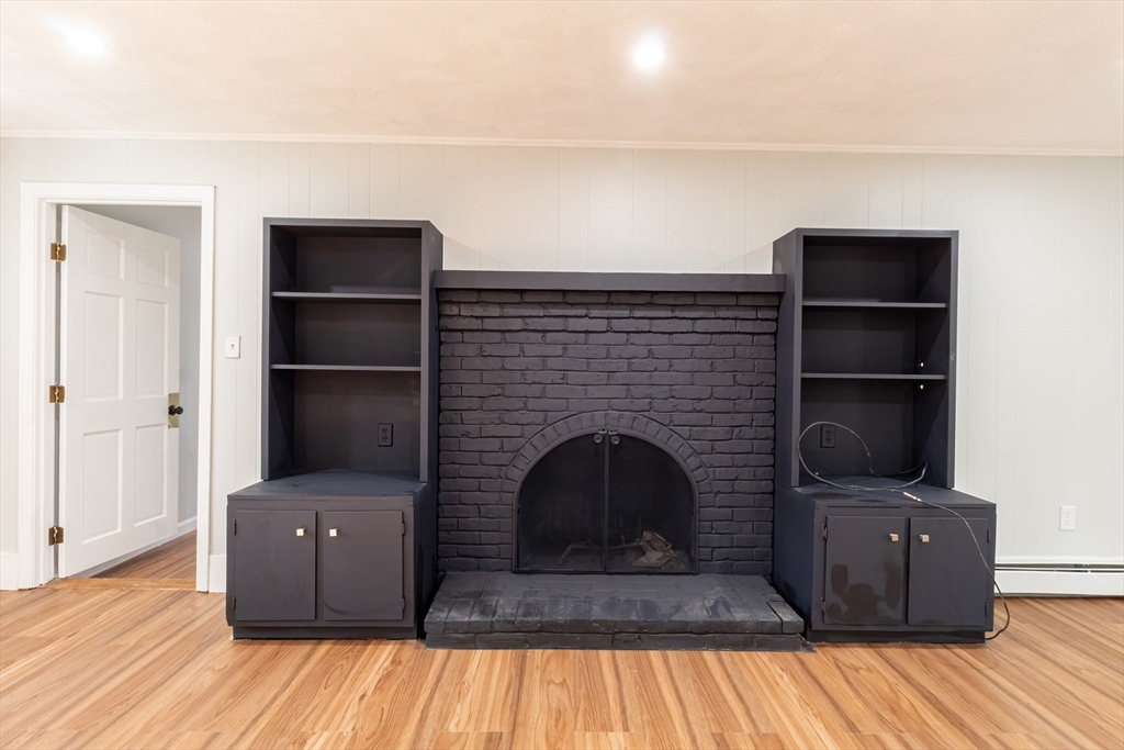 6 Kingsley Road Easton, MA 02356 - Photo 13 of 41 a living room with a fireplace and a wooden floor