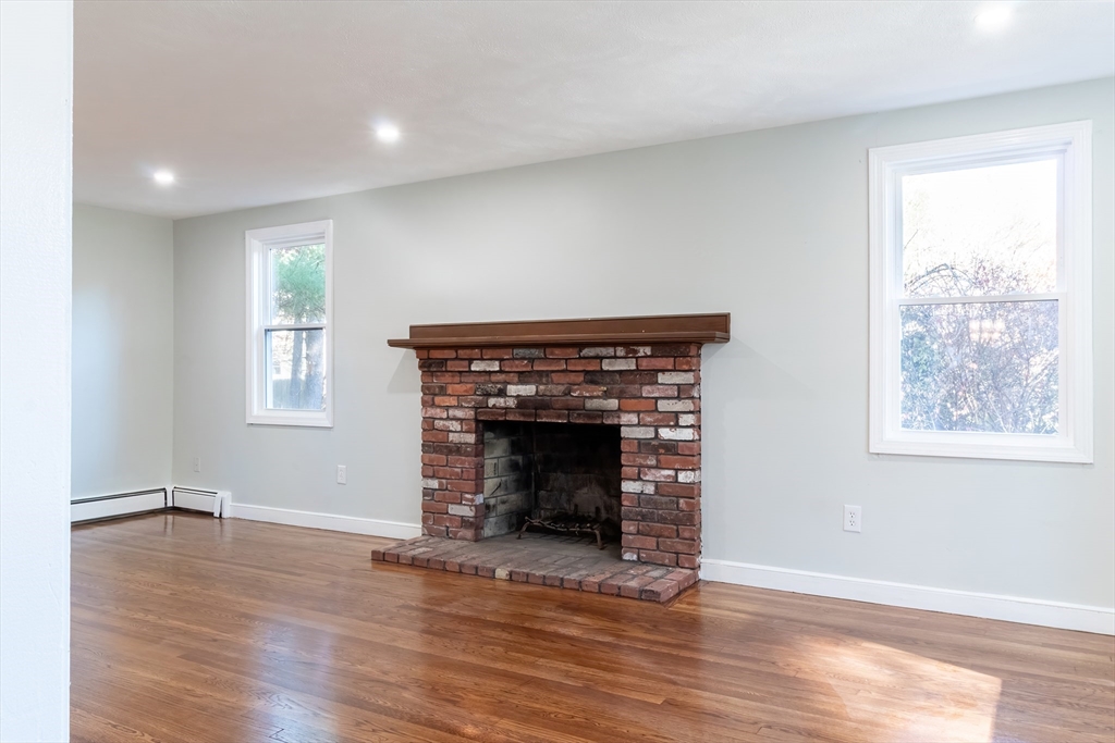6 Kingsley Road Easton, MA 02356 - Photo 16 of 41 an empty room with wooden floor fireplace and windows