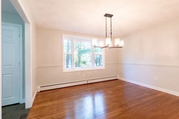 an empty room with wooden floor outdoor space and windows