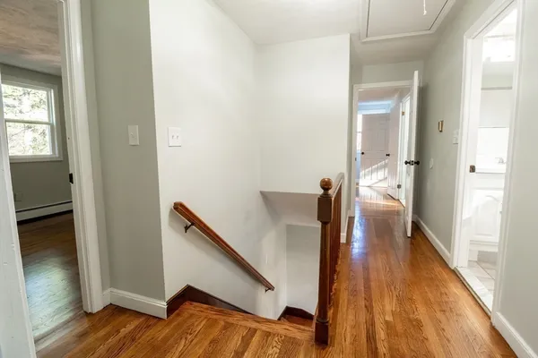 a view of a hallway with wooden floor and staircase