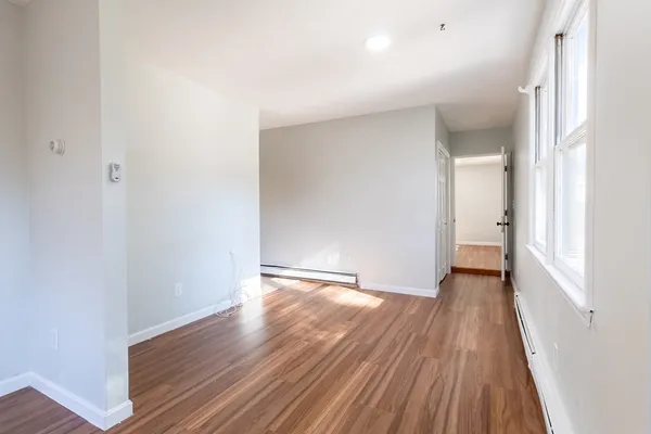 a view of an empty room with wooden floor