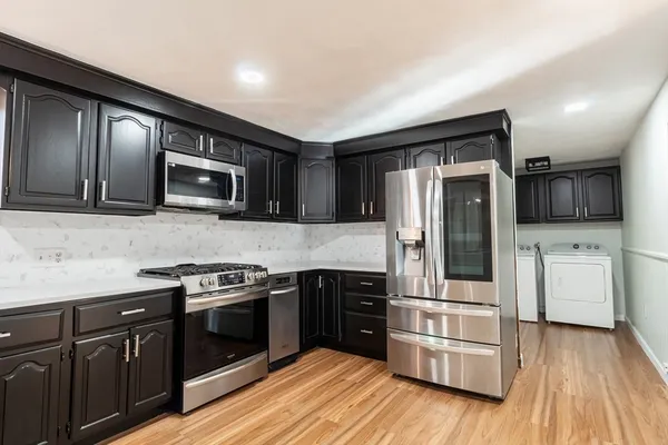 a kitchen with stainless steel appliances and wooden cabinets