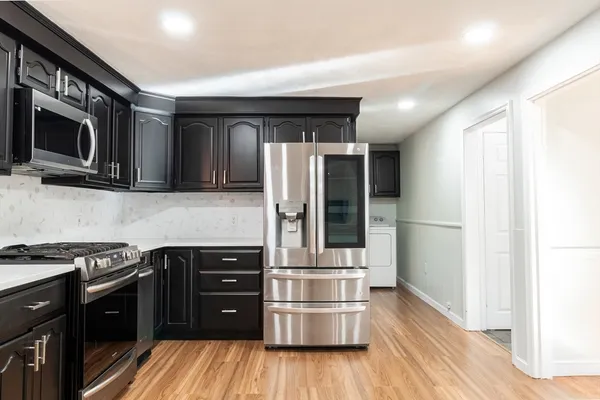a kitchen with stainless steel appliances granite countertop a refrigerator and a stove top oven