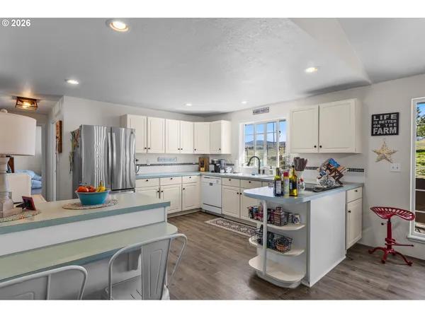 a kitchen with white cabinets and appliances