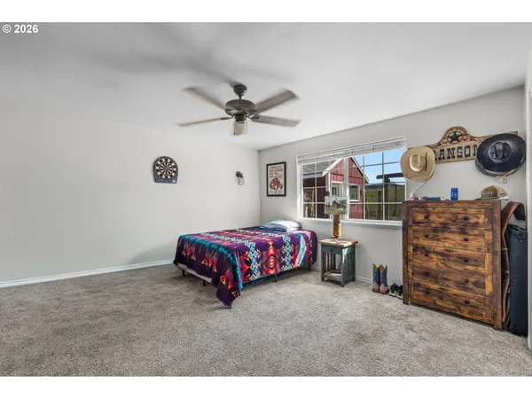 a bedroom with a bed a dresser and a chandelier