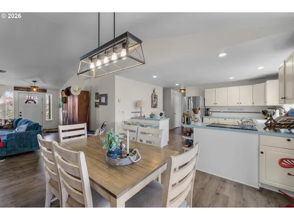 a kitchen with stainless steel appliances kitchen island granite countertop a table and chairs in it