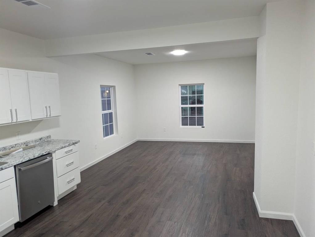 205 North Wood Street Cleburne, TX 76033 - Photo 5 of 15 a view of a kitchen with wooden floor and electronic appliances