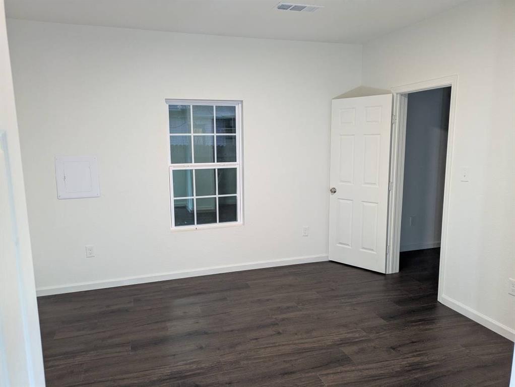 205 North Wood Street Cleburne, TX 76033 - Photo 6 of 15 an empty room with wooden floor and windows