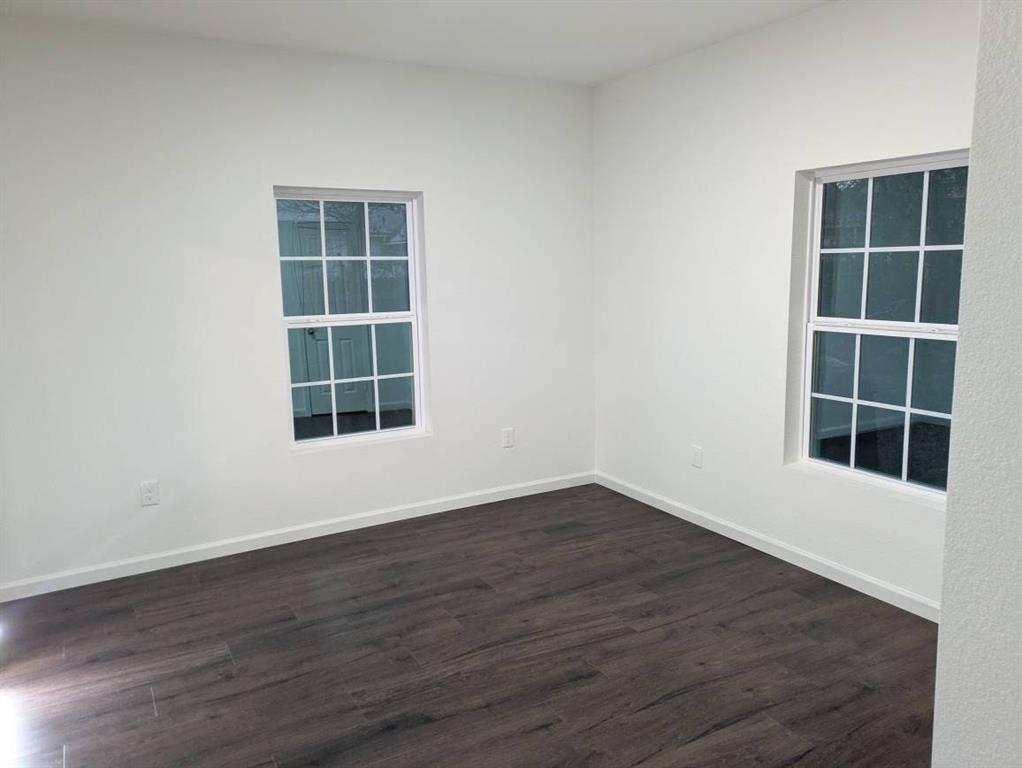 205 North Wood Street Cleburne, TX 76033 - Photo 8 of 15 an empty room with wooden floor and windows