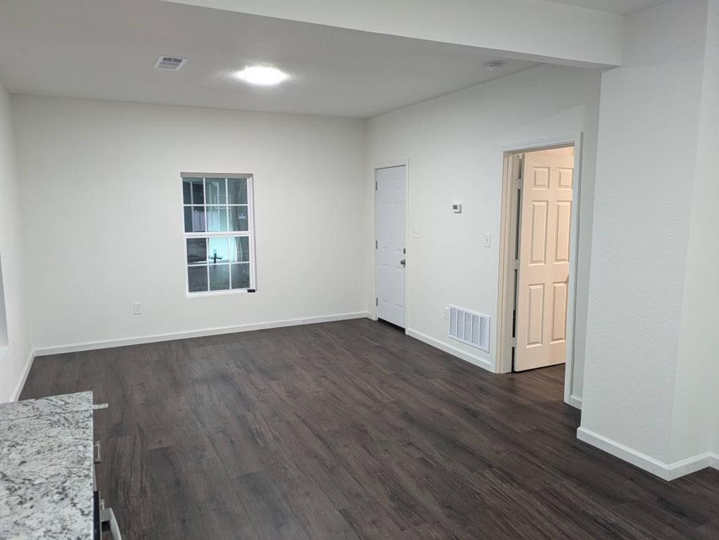 205 North Wood Street Cleburne, TX 76033 - Photo 9 of 15 an empty room with wooden floor and windows
