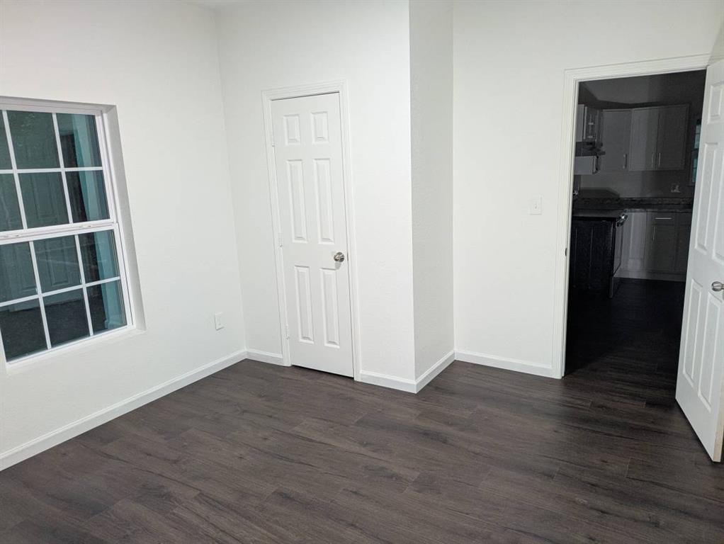 205 North Wood Street Cleburne, TX 76033 - Photo 10 of 15 a view of an empty room with wooden floor and a cabinet