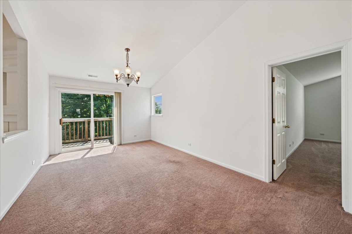 973 Park Hill Circle, Unit 973 Aurora, IL 60502 - Photo 9 of 17 a view of a big room with windows and chandelier fan