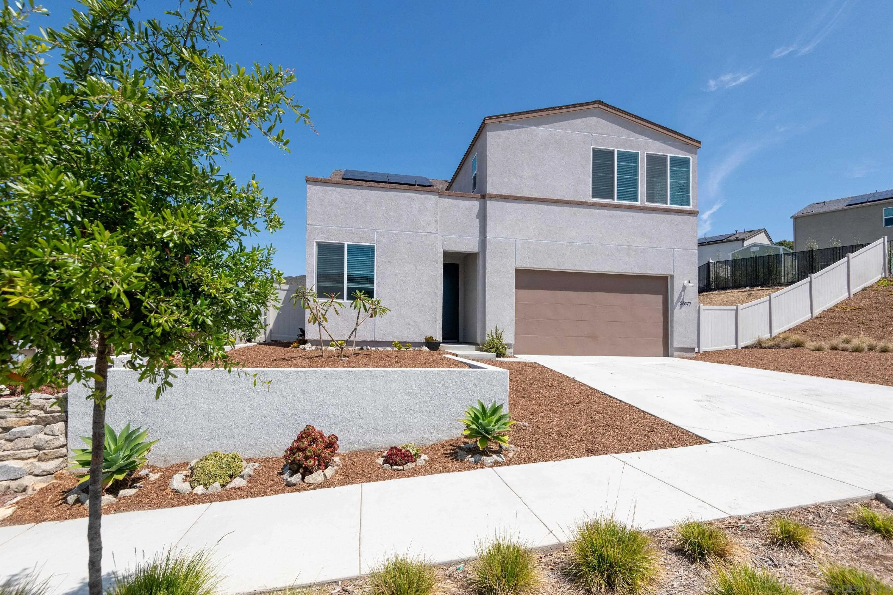 35177 Orchard Trail Fallbrook, CA 92028 - Photo 2 of 31 a front view of a house with a yard and garage