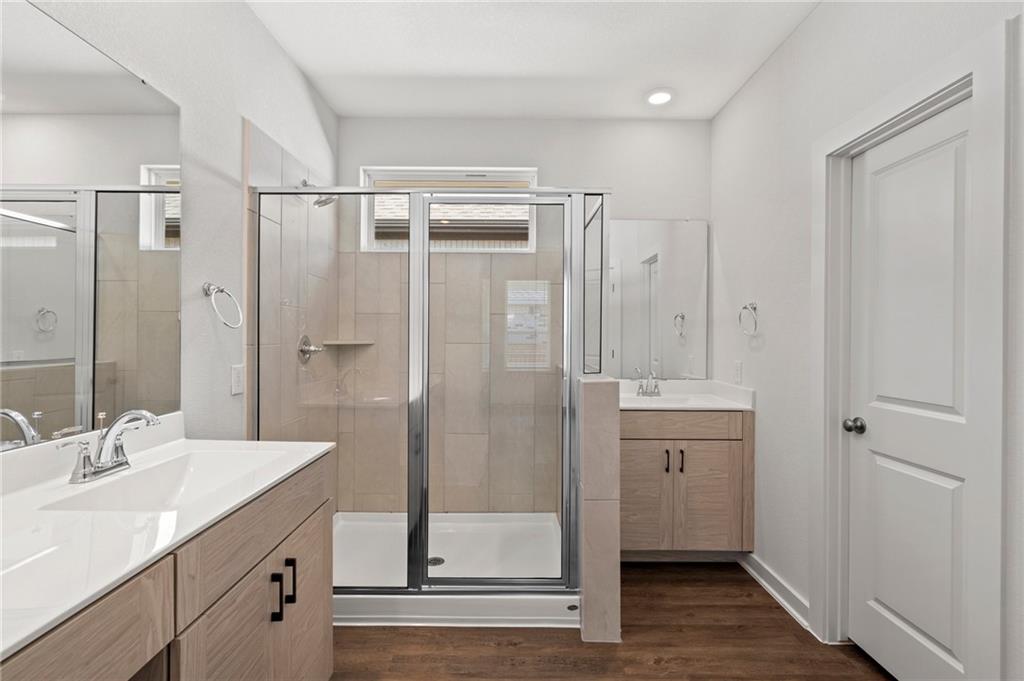 1012 Paddock Lane Georgetown, TX 78626 - Photo 6 of 15 Modern primary bathroom boasts dual vanities and a sleek glass-enclosed shower.