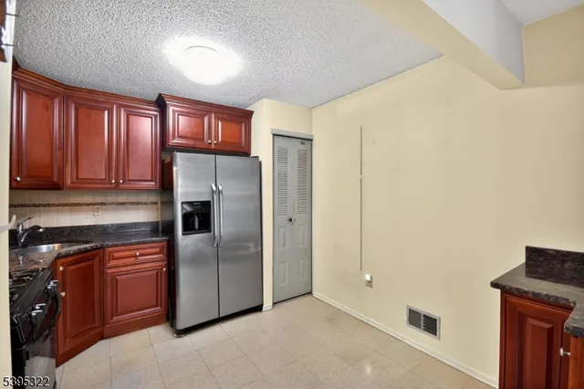 a kitchen with stainless steel appliances granite countertop a refrigerator and a stove