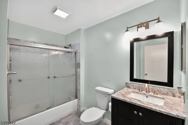 a bathroom with a granite countertop sink toilet and shower
