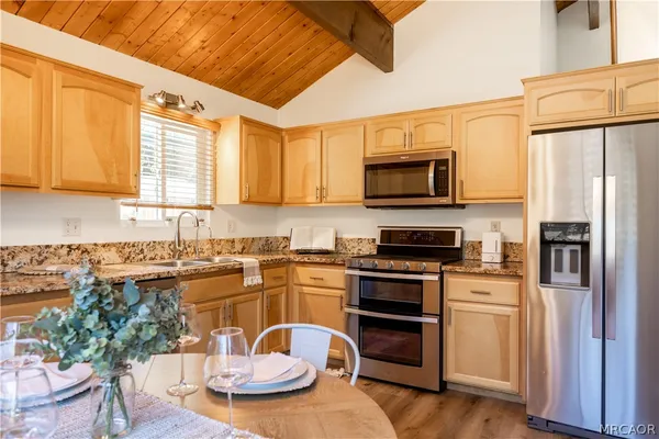 a kitchen with stainless steel appliances a stove a sink and a microwave