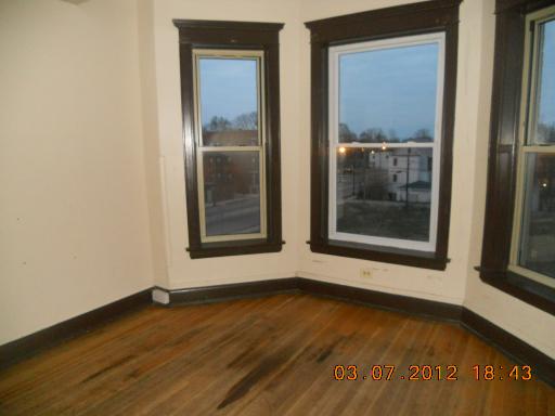 7108 South Normal Boulevard Chicago, IL 60621 - Photo 2 of 15 a view of an empty room with wooden floor and a window