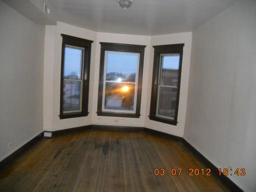 7108 South Normal Boulevard Chicago, IL 60621 - Photo 13 of 15 an empty room with wooden floor and windows