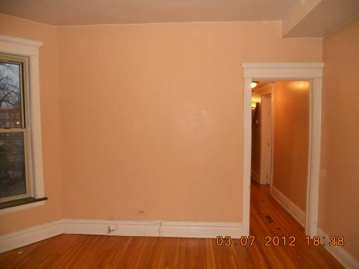 7108 South Normal Boulevard Chicago, IL 60621 - Photo 10 of 15 a view of an empty room with wooden floor and a window