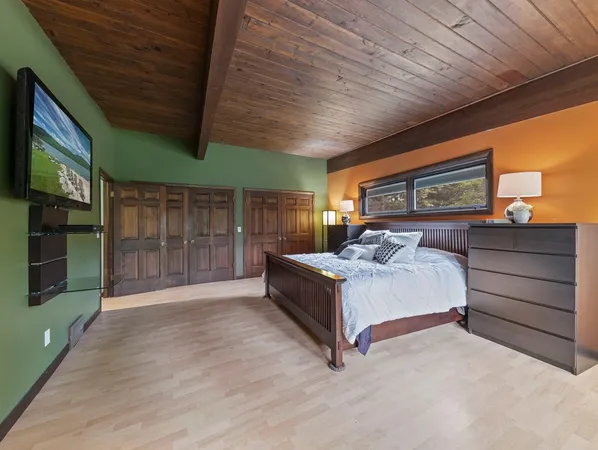 a spacious bedroom with a bed and a ceiling fan