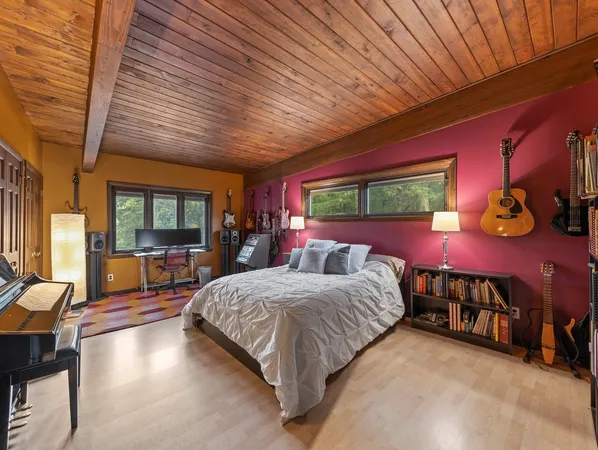 a bedroom with a bed and large windows