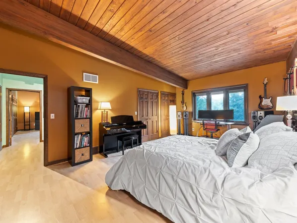 a bed sitting in a spacious bedroom next to a window