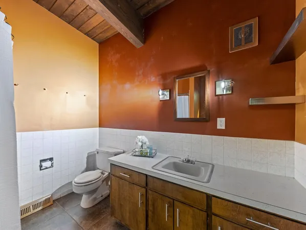 a bathroom with a sink a toilet and mirror