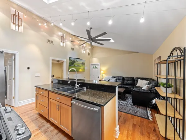 a kitchen with granite countertop a sink cabinets and wooden floor