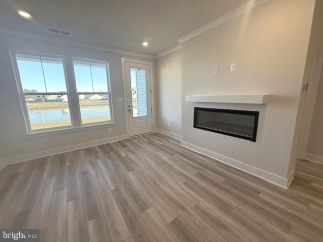 an empty room with windows and fireplace