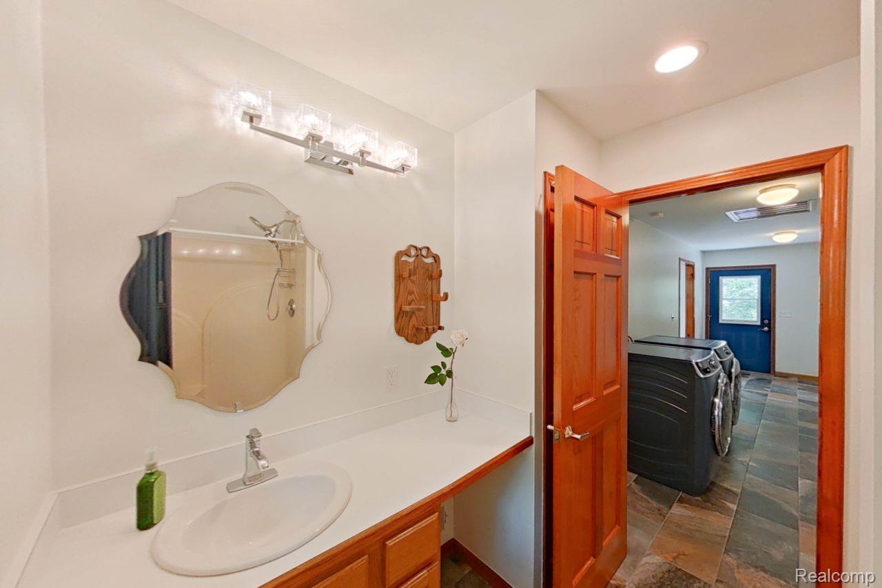 10201 Washburn Road Goodrich, MI 48438 - Photo 41 of 85 Vanity featuring a spacious countertop, integrated sink, and an ornate wall-mounted mirror