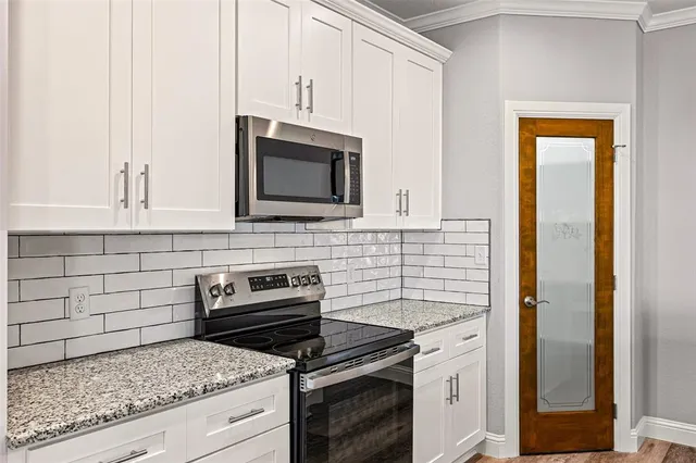 a kitchen with granite countertop cabinets stainless steel appliances and a counter space